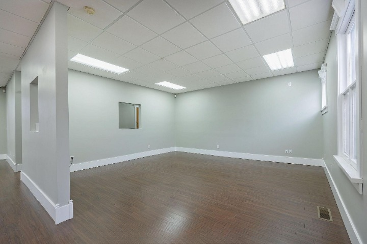 Bright open commercial room with large windows - empty
